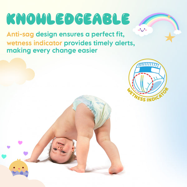 Baby doing a playful stretch wearing an IIT Silk diaper; colorful "KNOWLEDGEABLE" text, rainbow, hearts, and circular wetness-indicator graphic. 6th image.